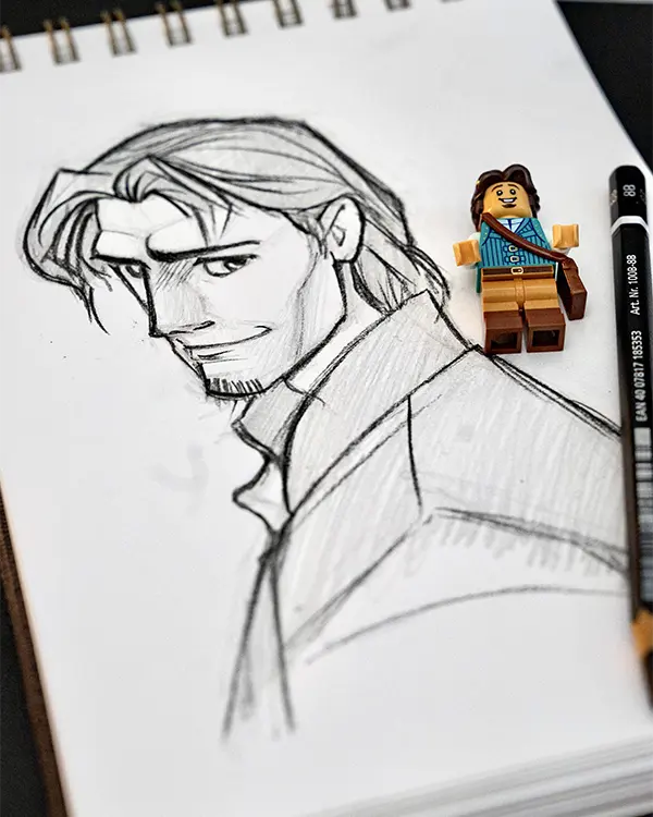 LEGO Flynn Rider minifigure placed beside a pencil sketch of his character from Tangled.