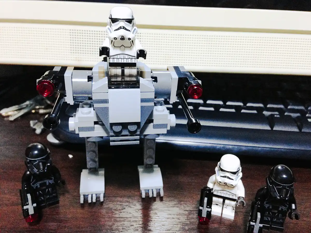 LEGO Stormtrooper minifigures and a mini walker assembled on a desk, ready for battle.