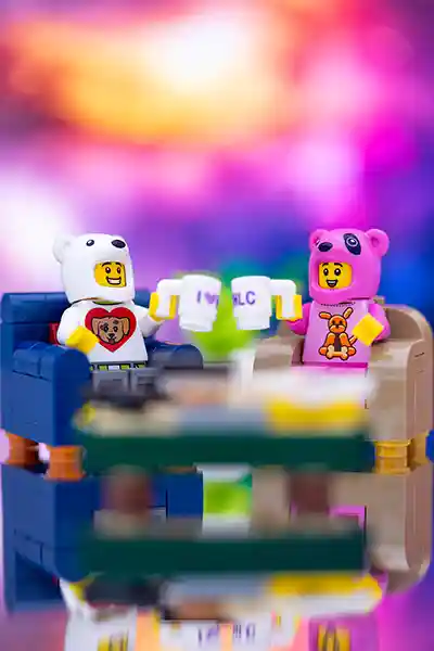 LEGO minifigures in dog and bear costumes gather in a playful club setting, surrounded by colorful bricks and animal-themed accessories.