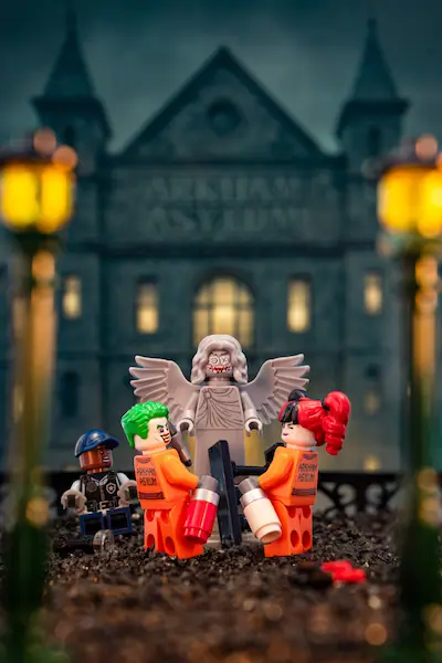 LEGO DC Arkham Asylum scene with a vandalized status with LEGO Joker and Harley Quinn.