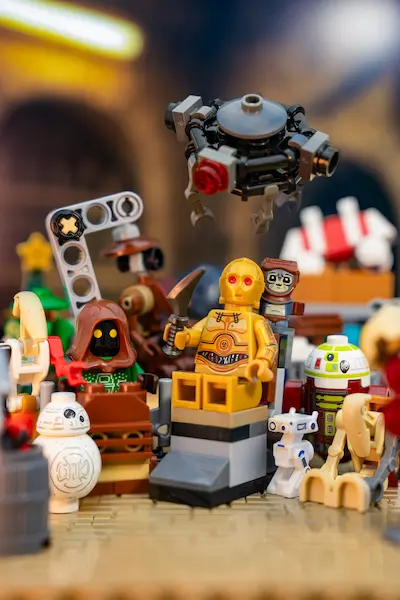 LEGO Star Wars Advent Calendar scene with Sith C-3PO holding a weapon, surrounded by small droids and mini builds, with Babu Frik behind him.