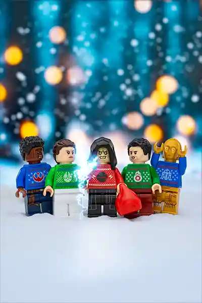 LEGO Star Wars minifigures in Christmas sweaters standing in the snow, with Emperor Palpatine dramatically summoning Force lightning.