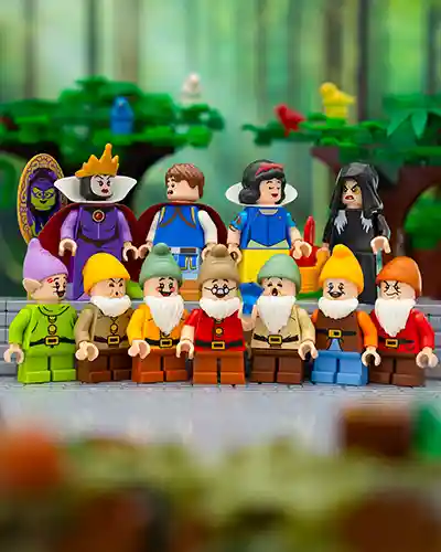 LEGO Snow White stands in a forest clearing with the Seven Dwarfs, surrounded by woodland animals and a cozy cottage in the background. The scene is bright and cheerful, capturing the classic fairy tale moment.