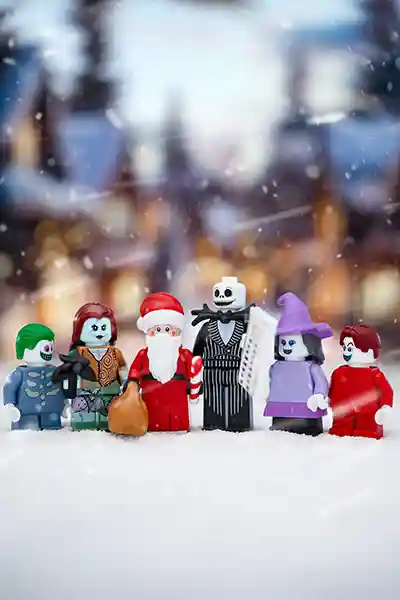 LEGO minifigures of Jack Skellington, Sally, Santa, and others from The Nightmare Before Christmas posed in a snowy village scene.