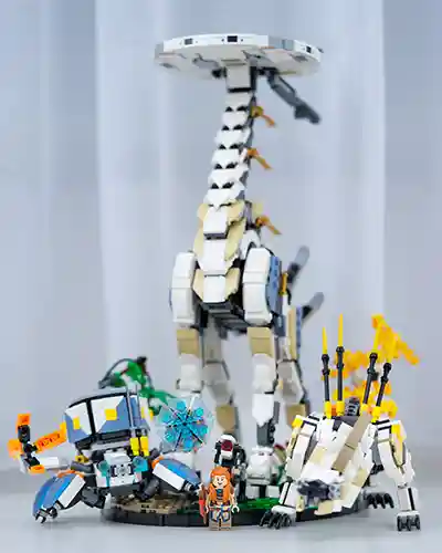 LEGO Horizon Forbidden West machines including a Tallneck, Watcher, and Clawstrider recreated in brick form, posed in a dramatic landscape with Aloy minifigure observing.