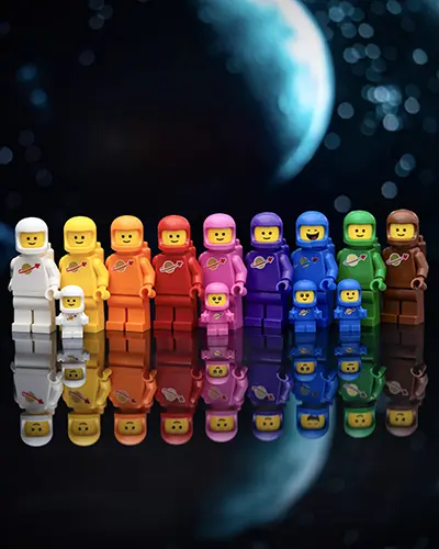 A lineup of LEGO Classic Space minifigures in a rainbow of colors, reflected on a glossy surface with a distant blue planet in the background.