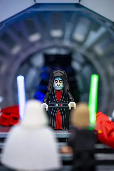 LEGO Emperor Palpatine flanked by two red Royal Guards in the Death Star's throne room.